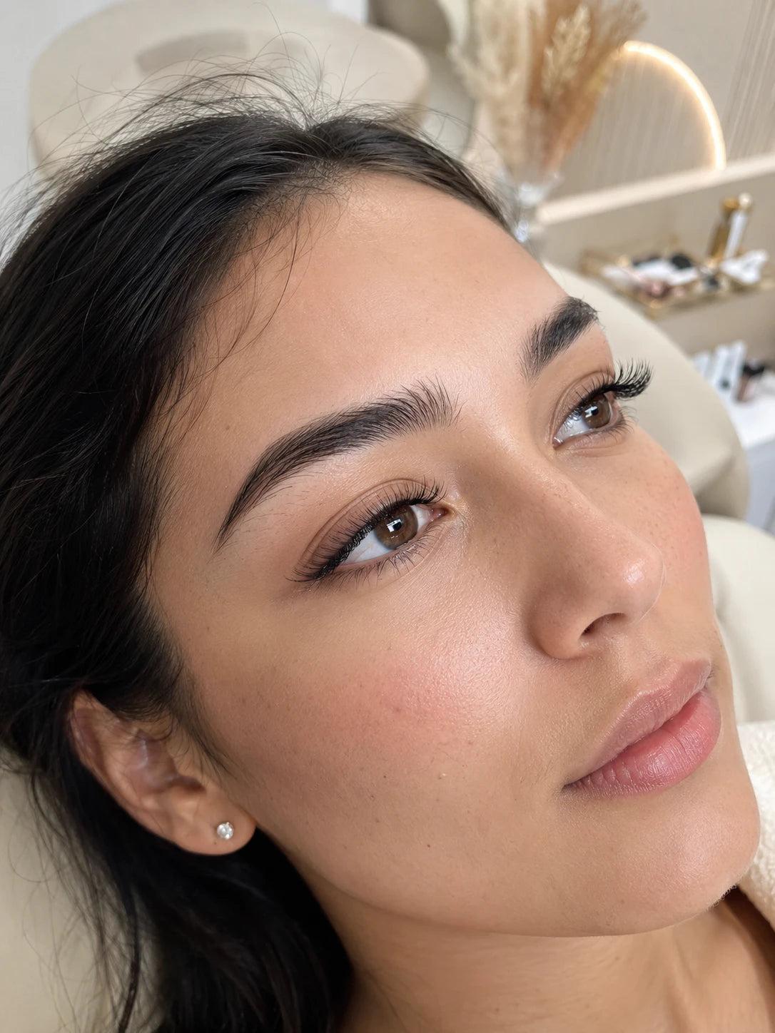 Close-up of soft natural eyelash extensions and groomed eyebrows on a female client near Chiswick