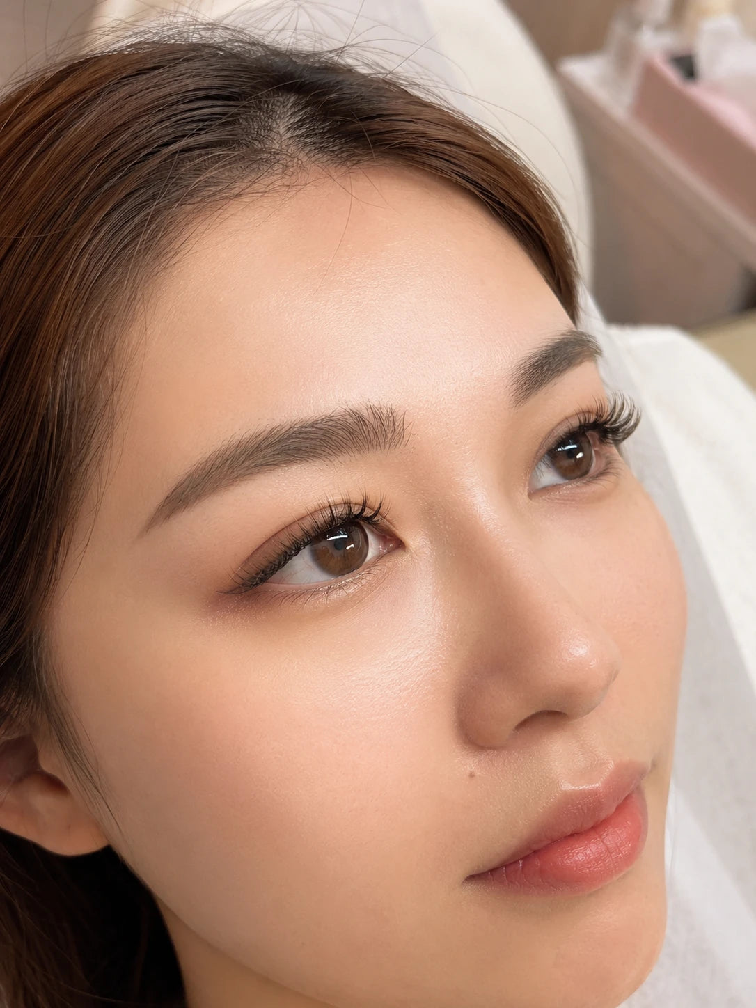 Close-up of natural eyelash extensions and groomed eyebrows on a female client near Eastwood