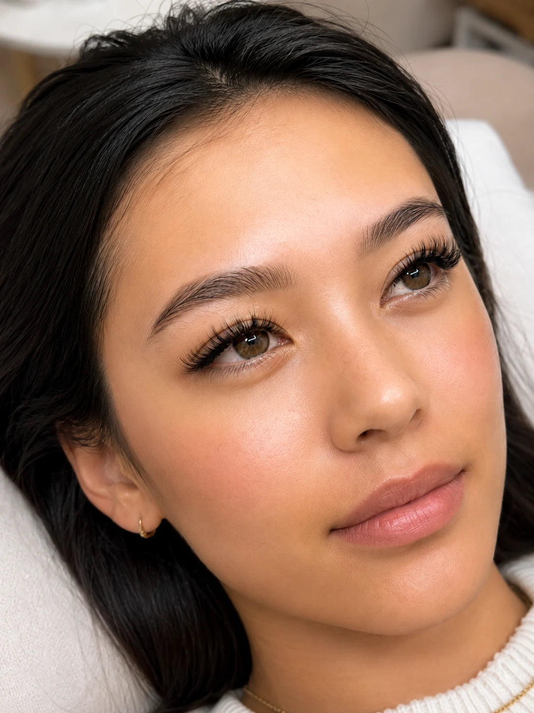 Close-up of natural volume eyelash extensions and groomed eyebrows on a female client near Eastwood