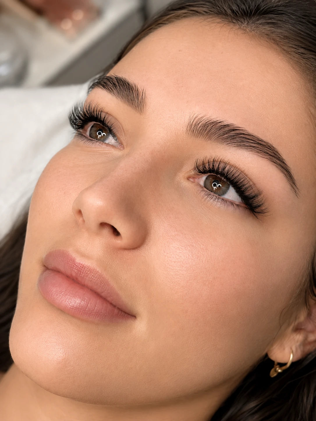 Close-up of soft volume eyelash extensions and groomed eyebrows on a female client near Balmain
