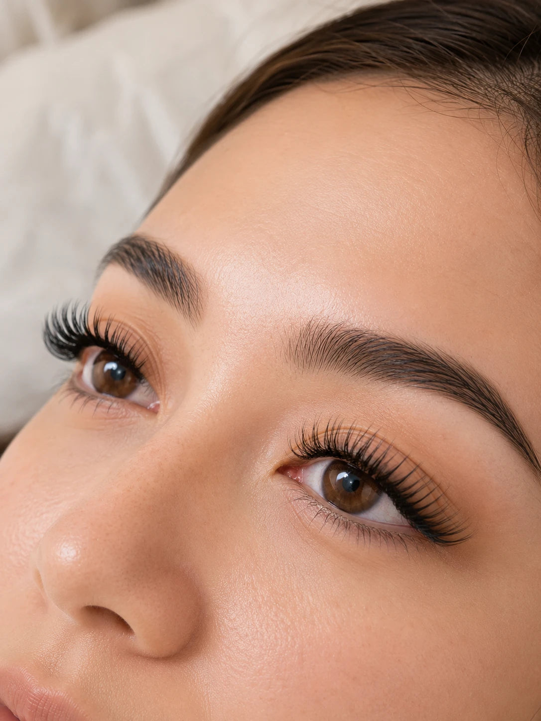 Close-up of curled eyelash extensions and groomed eyebrows on a female client near Concord