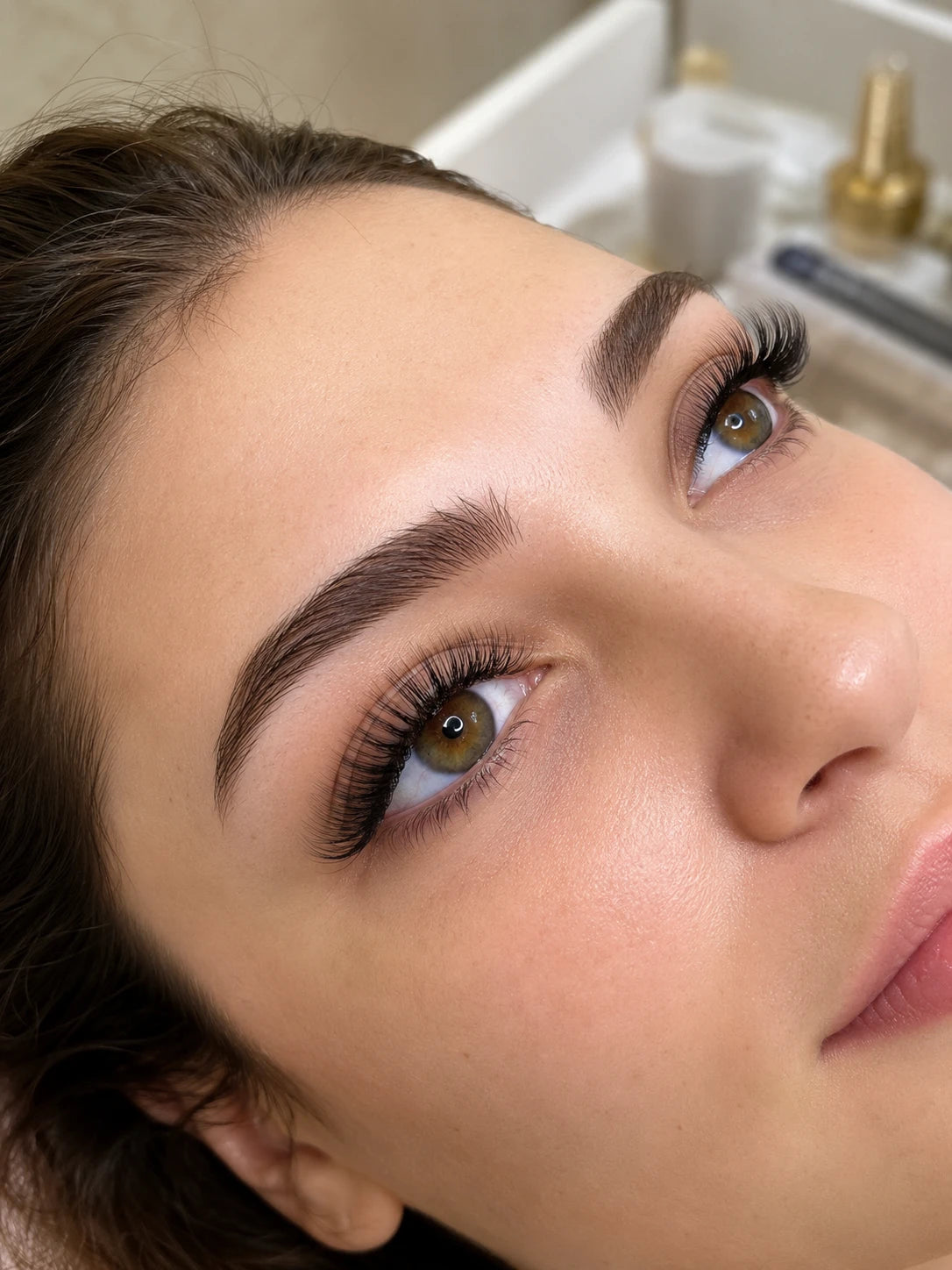 Close-up of full curled eyelash extensions and groomed eyebrows on a female client near Concord