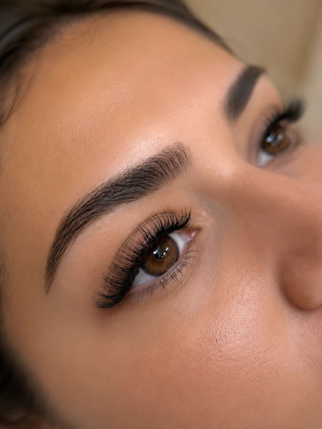 Close-up of full curled eyelash extensions and groomed eyebrows on a female client near Rhodes