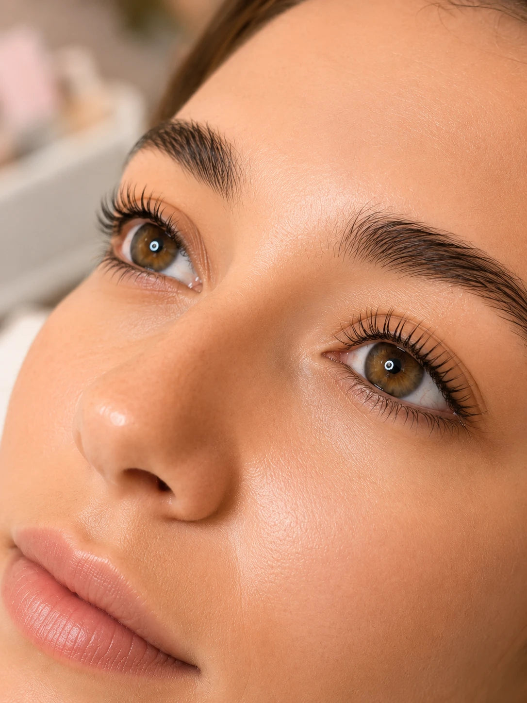 Close-up of naturally lifted lashes and groomed eyebrows on a female client near Balmain