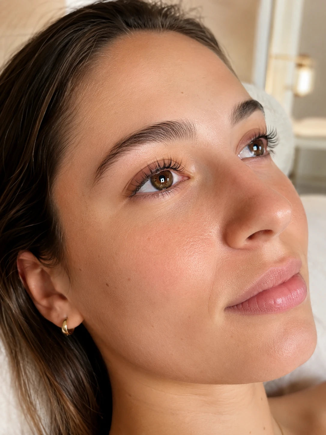 Close-up of softly lifted natural lashes and groomed eyebrows on a female client near Putney