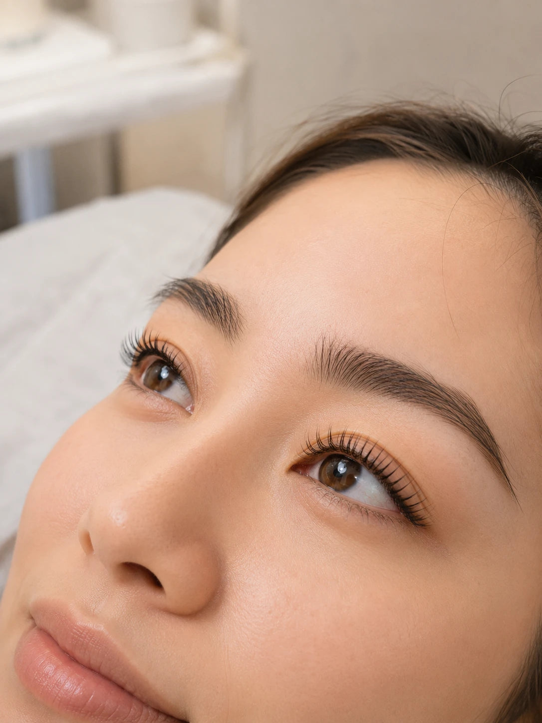 Close-up of natural lifted lashes and groomed eyebrows on a female client near Ryde