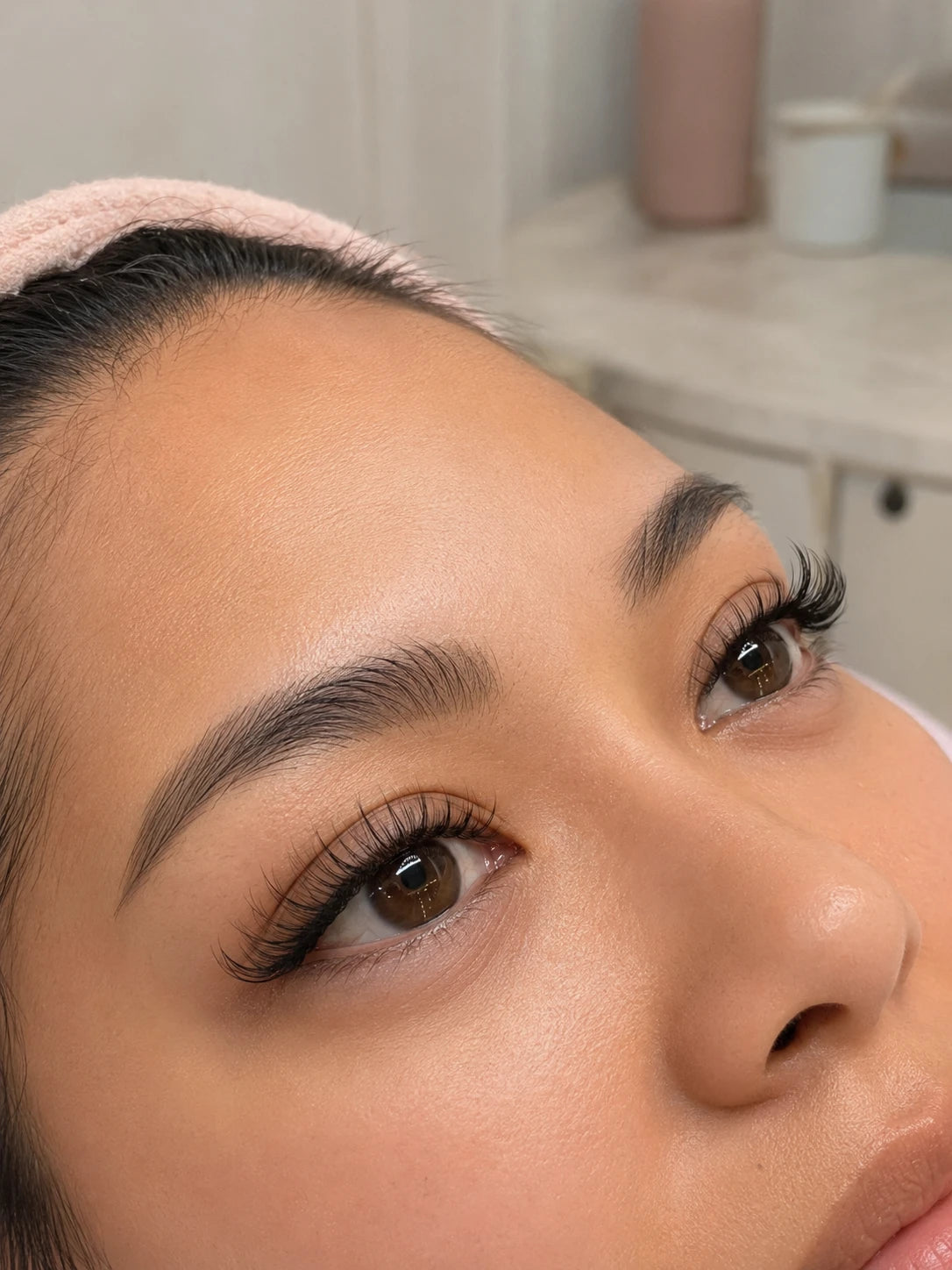Close-up of natural volume lashes and groomed eyebrows on a female client near Putney