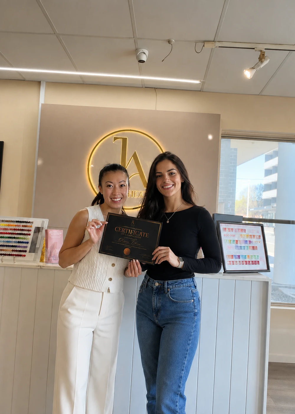 Nail course graduate holding a completion certificate with an educator at J.Aesthetic in Sydney
