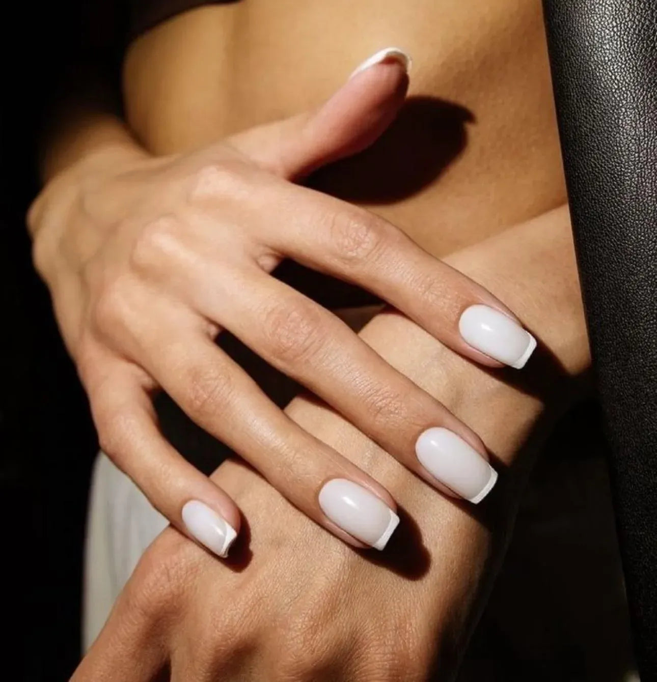 Close-up of short square nails with a milky white Russian manicure finish